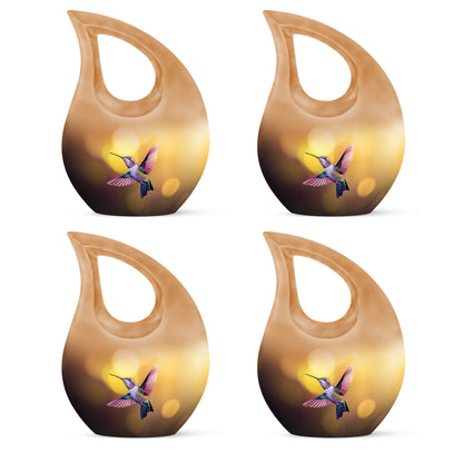 Amber Gold Hummingbird Cremation Urn lifestyle display on memorial shelf - sacred cross merged with hummingbird motif on metal - 10 inch aluminum urn for cremated remains