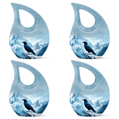Slate Blue Crow Cremation Urn lifestyle display on memorial shelf - cross and crow combined in spiritual memorial design - 10 inch aluminum urn for cremated remains