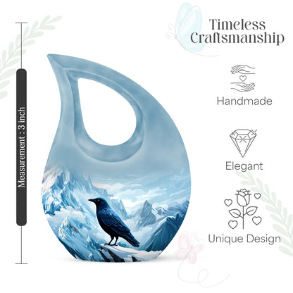 Pastel Blue Crow Cremation Urn back view with polished surface - sacred cross merged with crow motif on metal - mini keepsake memorial for portion of cremation ashes