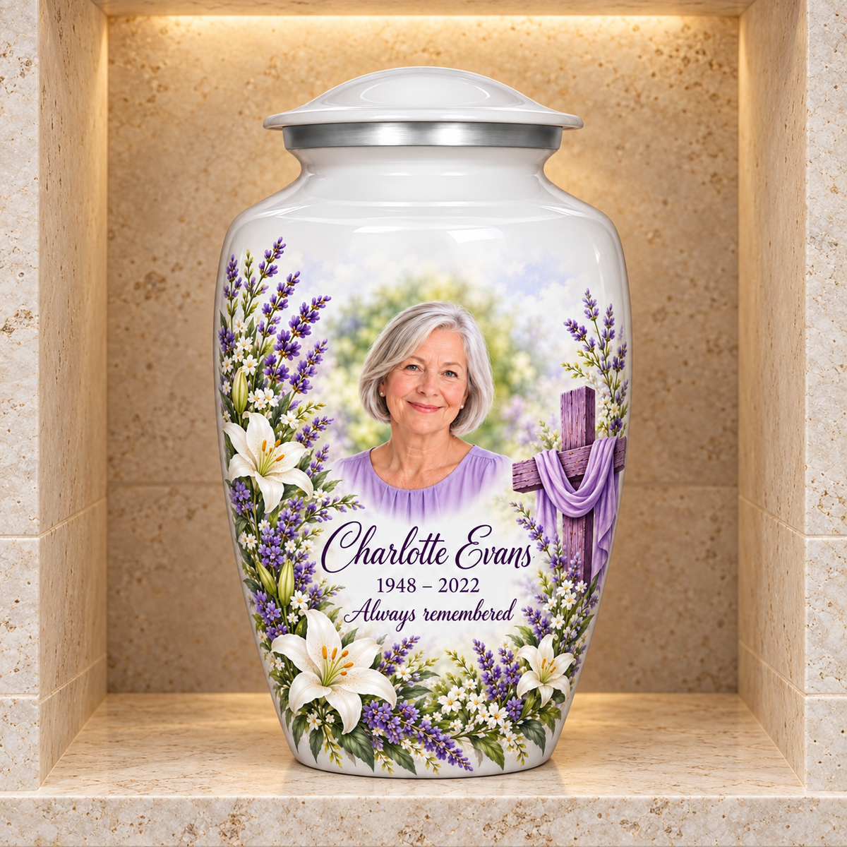 White adult cross urn with white lilies and lavender displayed in a stone columbarium niche.