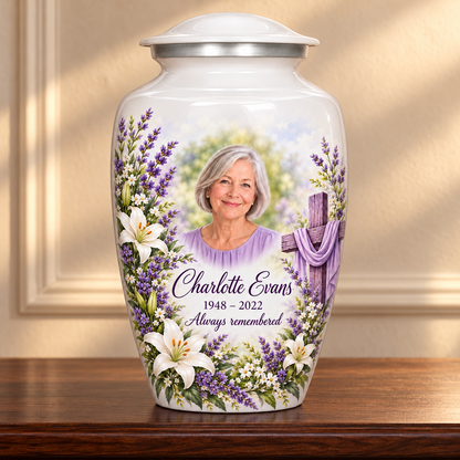White adult cross urn with white lilies and lavender displayed on a memorial console.