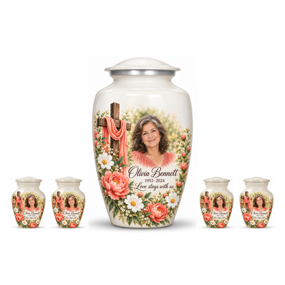 One white adult cross urn and four keepsakes with coral flowers and white daisies arranged on white.