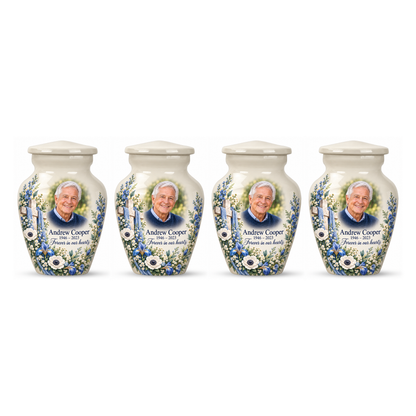 Four matching white cross keepsake urns with blue and white flowers arranged on white.