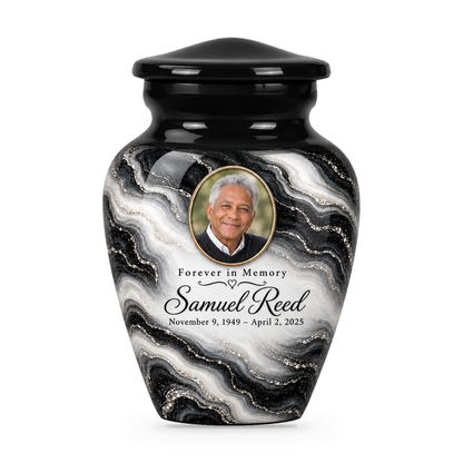 One Black Pearl charcoal and white keepsake urn with a sample portrait, name and dates.