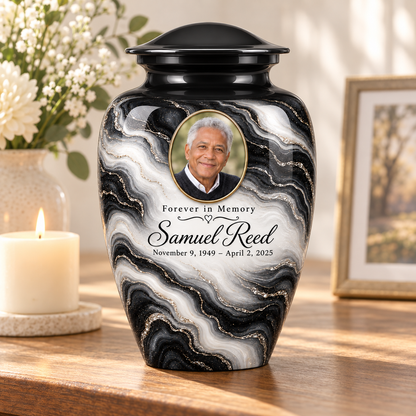 Black Pearl adult urn on a memorial console beside a candle and flowers.