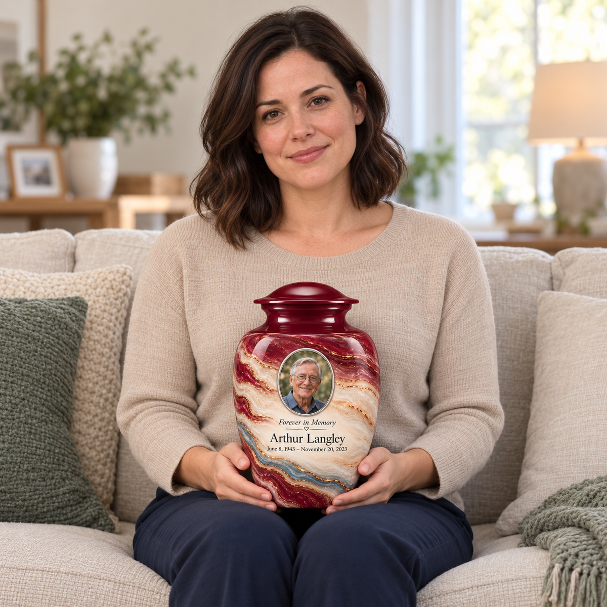 An adult woman holds the Burgundy Fold photo urn on her lap, showing its scale.