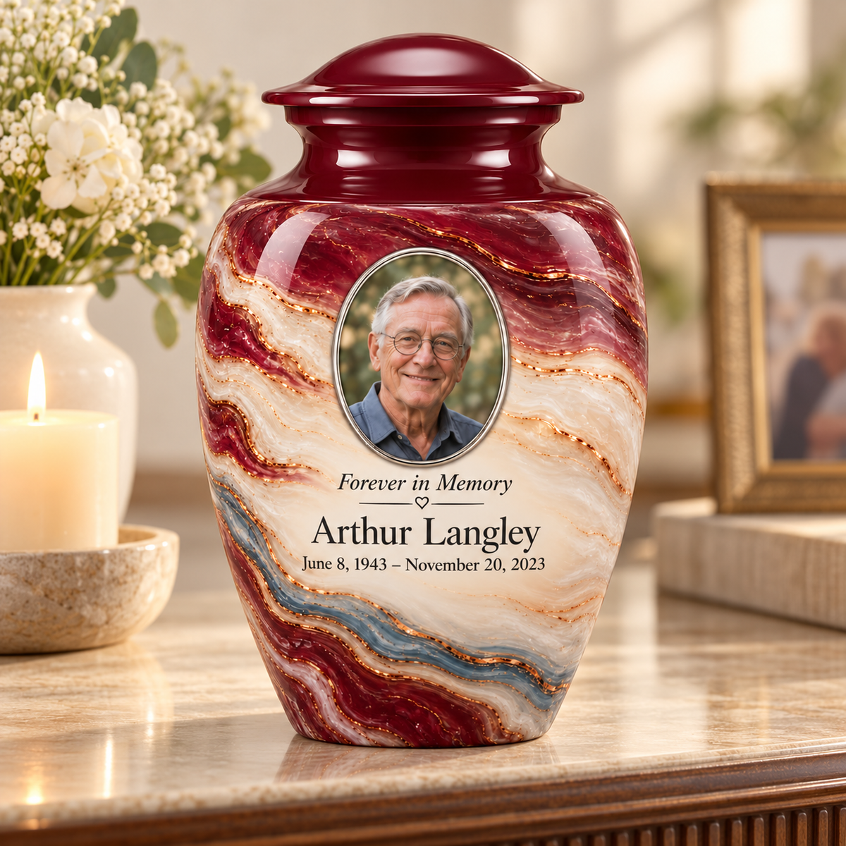 Burgundy Fold adult urn on a memorial console beside a candle and flowers.
