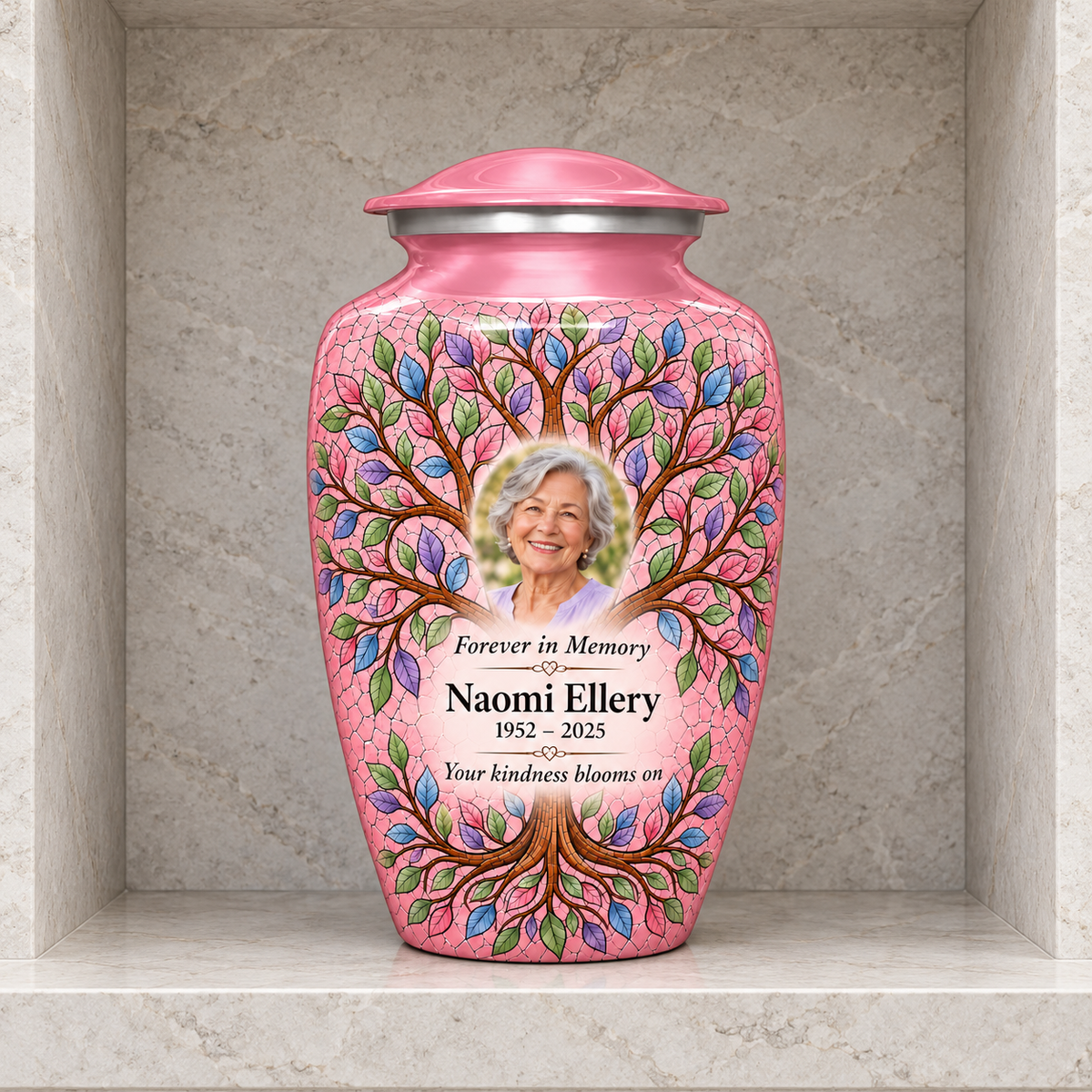 Pink Tree of Life adult urn with Naomi Ellery sample portrait and memorial text inside a pale stone columbarium niche.