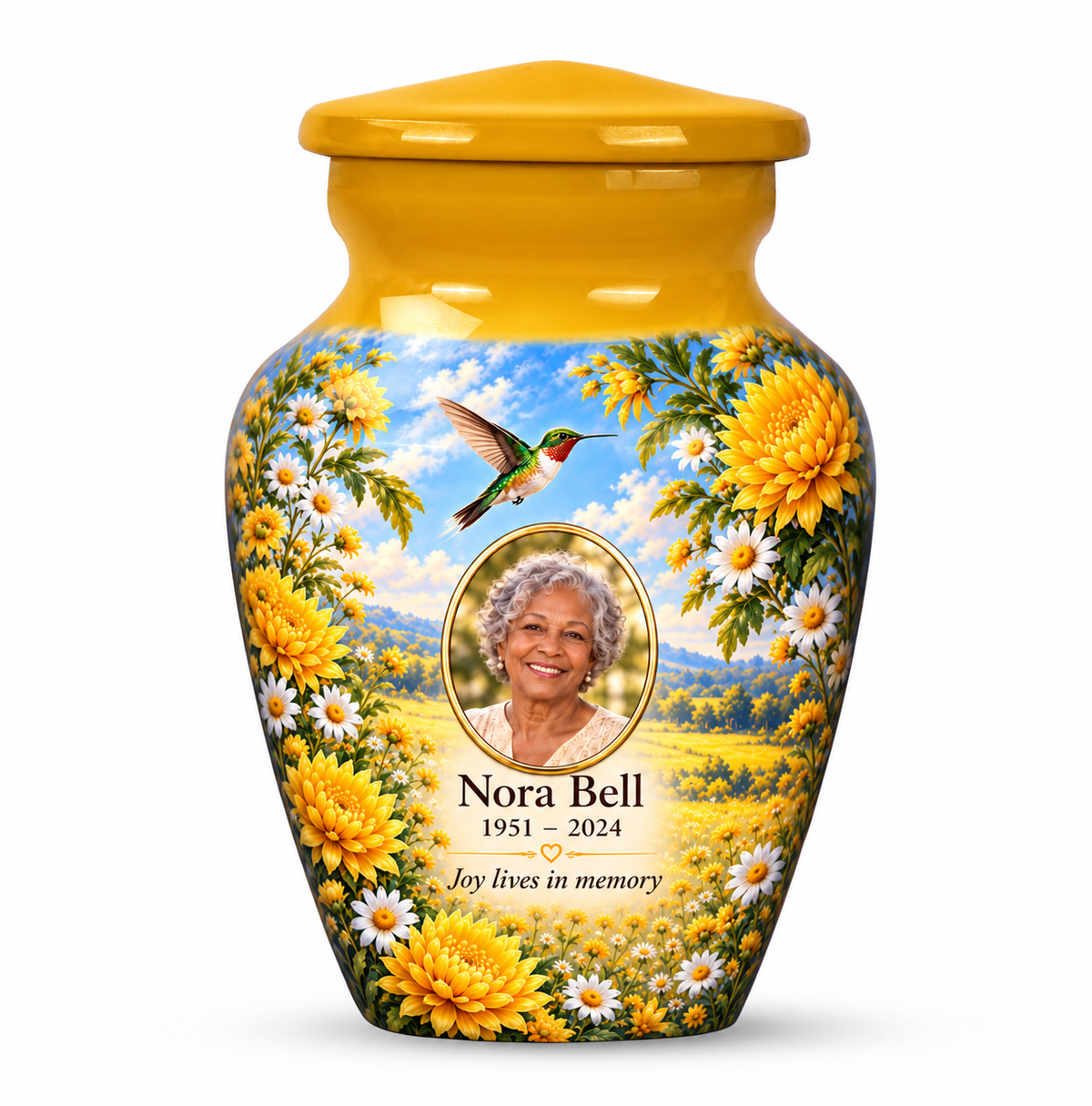 One yellow hummingbird keepsake urn with chrysanthemums, white daisies, gold oval sample portrait and Nora Bell text