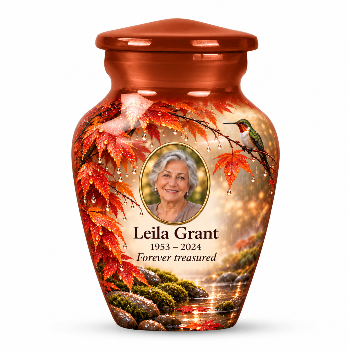 One orange hummingbird keepsake urn with maple leaves, raindrops and mossy stones and Leila Grant sample photo and text