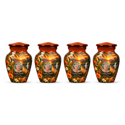 Four matching orange hummingbird keepsake urns with Lydia Finch sample photo and text