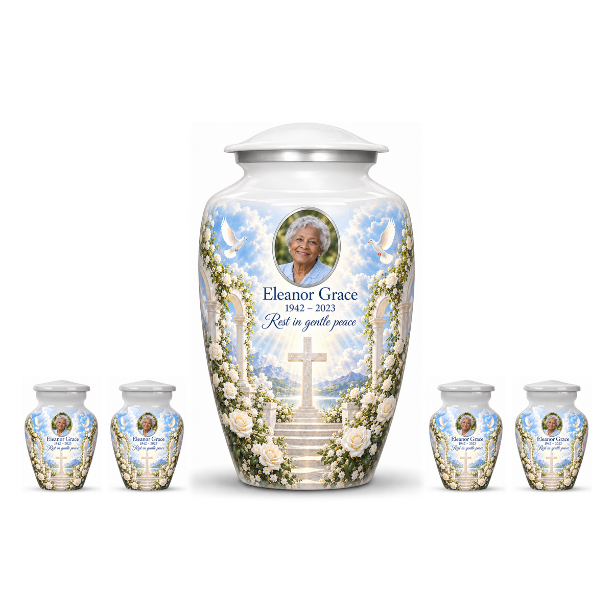 One white adult cross urn and four keepsakes with white roses and garden steps arranged on white.