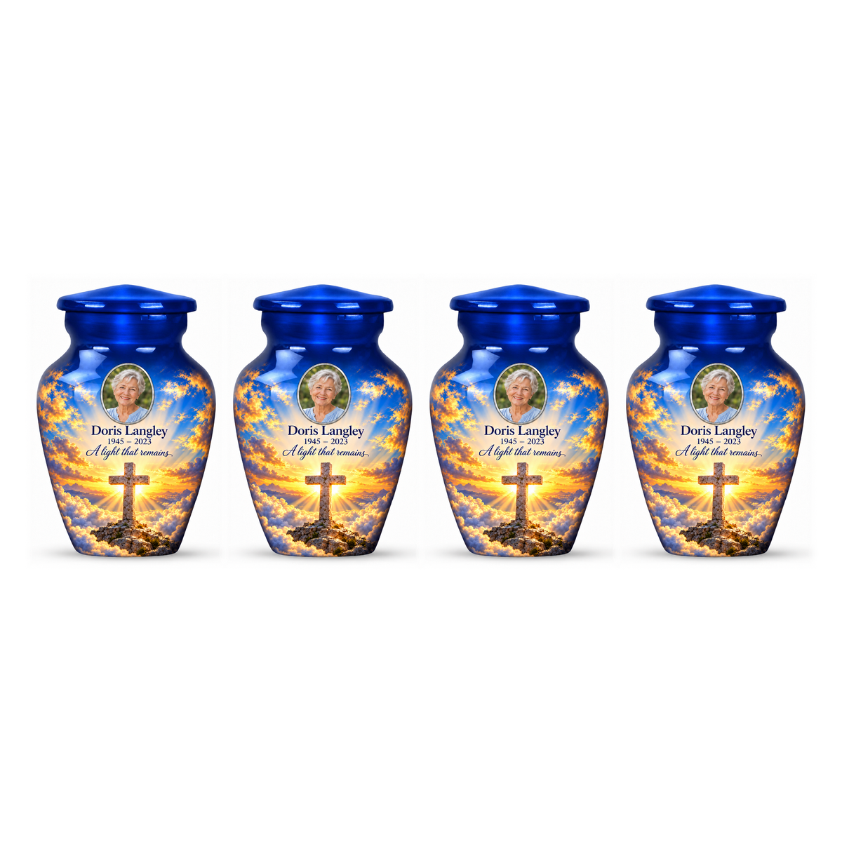 Four matching blue cross keepsake urns with golden sunlight and clouds arranged on white.
