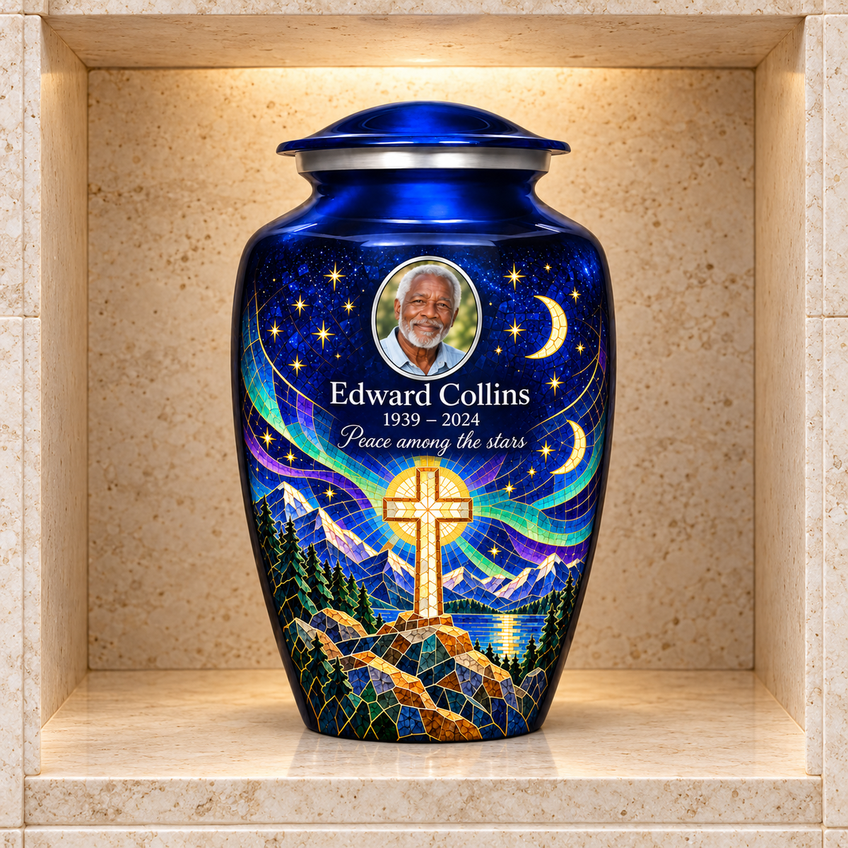 Blue adult cross urn with a printed moonlit mosaic displayed in a stone columbarium niche.