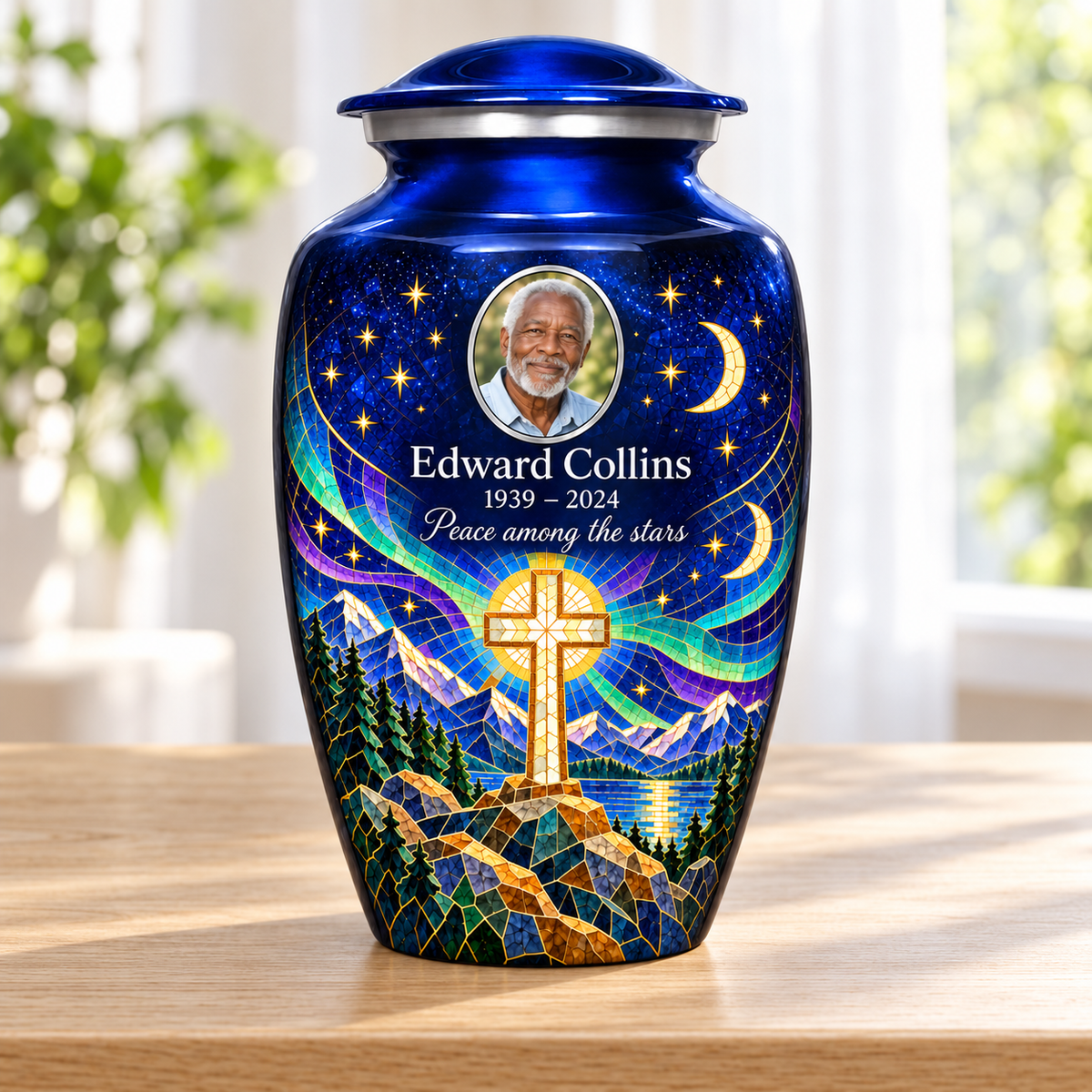 Blue adult cross urn with a printed moonlit mosaic beside a sunlit window.