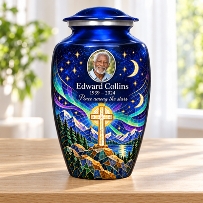 Blue adult cross urn with a printed moonlit mosaic beside a sunlit window.