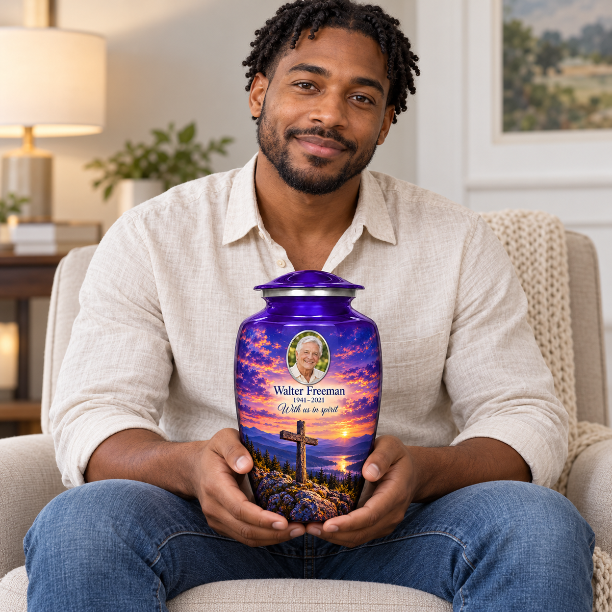 A seated person holding the purple cross urn with purple mountain twilight on their lap.