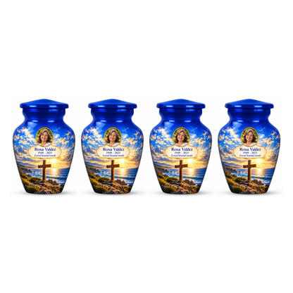 Four matching blue cross keepsake urns with a blue coastal sunset arranged on white.