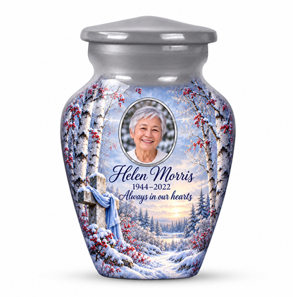 One silver cross keepsake urn with snowy birches and red berries, sample portrait and tribute on white.
