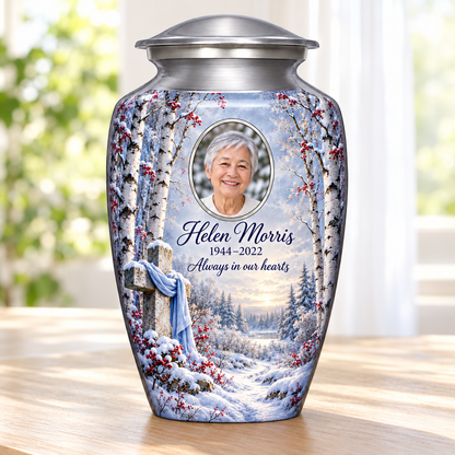 Silver adult cross urn with snowy birches and red berries beside a sunlit window.