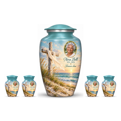 One green adult cross urn and four keepsakes with sandy dunes and sea arranged on white.