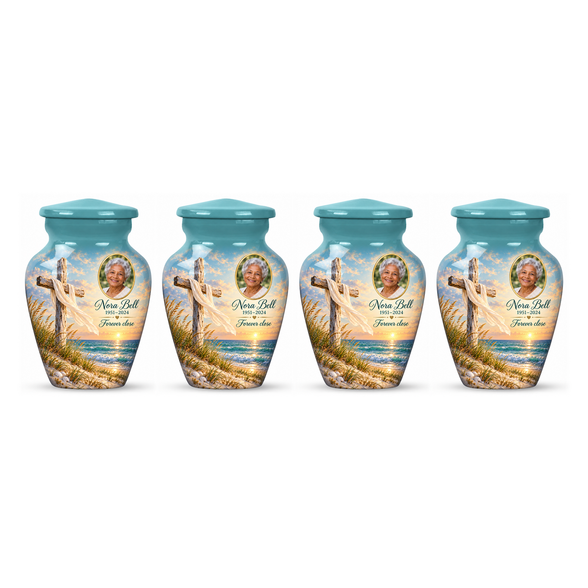 Four matching green cross keepsake urns with sandy dunes and sea arranged on white.