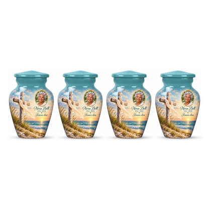 Four matching green cross keepsake urns with sandy dunes and sea arranged on white.