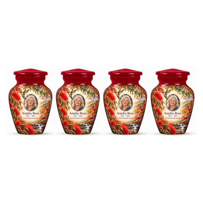 Four matching crimson red hummingbird keepsake urns in a row on white, each with Amelia Ross sample portrait and memorial text.