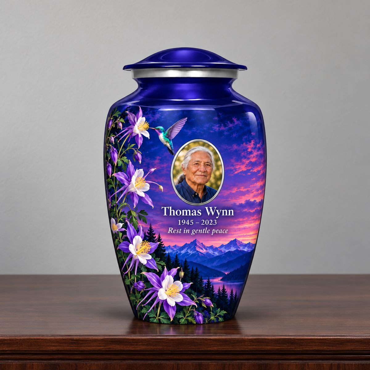 Indigo blue hummingbird adult urn with Thomas Wynn sample portrait and memorial text on a wooden memorial console.