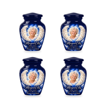 Four matching blue angel wings keepsake urns with sample photo and inscription.
