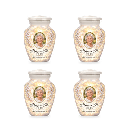 Four matching white angel wings keepsake urns with sample photo and inscription.