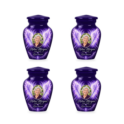 Four matching purple angel wings keepsake urns with sample photo and inscription.