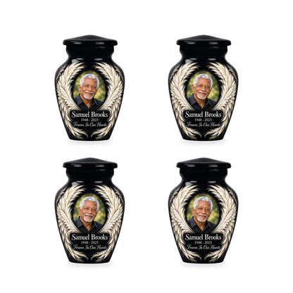 Four matching black angel wings keepsake urns with sample photo and inscription.