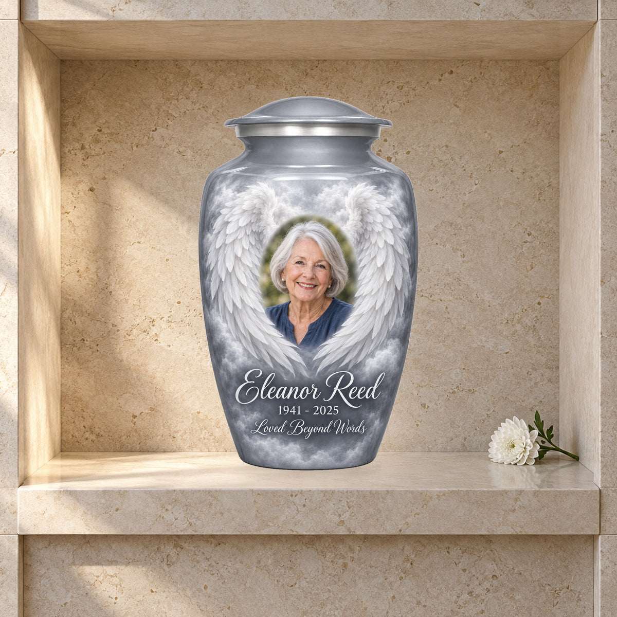 gray adult urn with Silver Mist Wings angel wings artwork displayed in a columbarium niche.