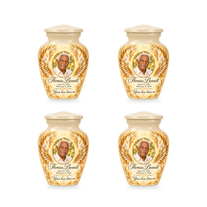 Four matching white angel wings keepsake urns with sample photo and inscription.