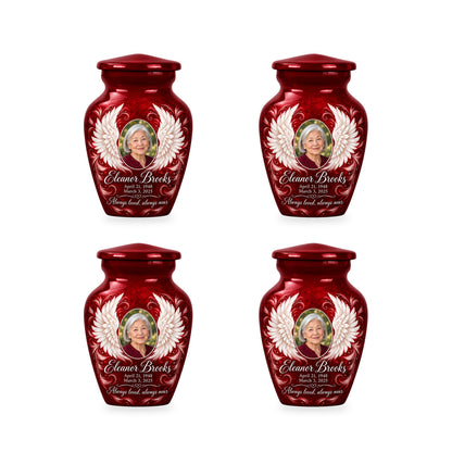 Four matching red angel wings keepsake urns with sample photo and inscription.