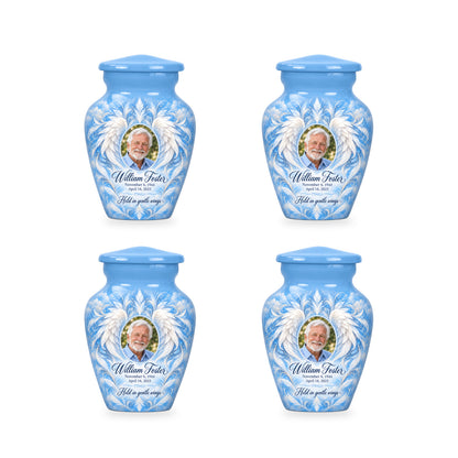 Four matching blue angel wings keepsake urns with sample photo and inscription.