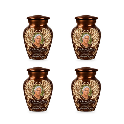 Four matching brown angel wings keepsake urns with sample photo and inscription.