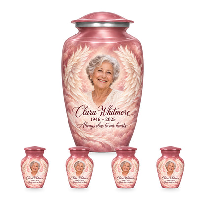 pink adult angel wings urn with four matching keepsakes shown in proportional 10-inch and 3-inch sizes.