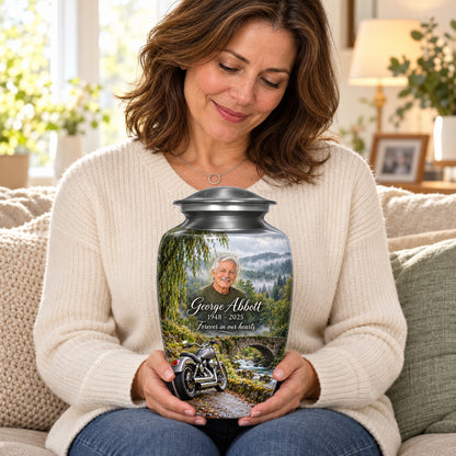 Seated person holding the adult Stonebridge Journey motorcycle urn on their lap.