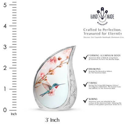 Polished Silver Hummingbird Cremation Urn angled view of lid and engraved motif - smooth teardrop contour featuring hummingbird art - mini keepsake memorial for portion of cremation ashes
