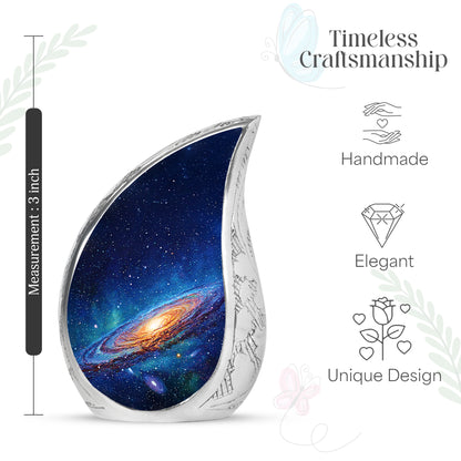 Bright Blue Galaxy Cremation Urn angled view of lid and engraved motif - graceful tear-shaped urn with galaxy motif - mini keepsake memorial for portion of cremation ashes