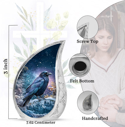 Icy Blue Crow Cremation Urn angled view of lid and engraved motif - flowing teardrop crow silhouette on curved aluminum - mini keepsake memorial for portion of cremation ashes