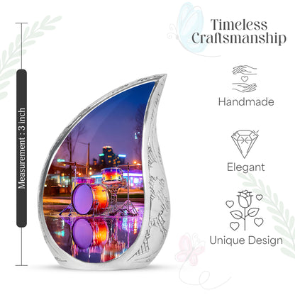 Icy Blue Drums Cremation Urn angled view of lid and engraved motif - flowing teardrop drums silhouette on curved aluminum - mini keepsake memorial for portion of cremation ashes