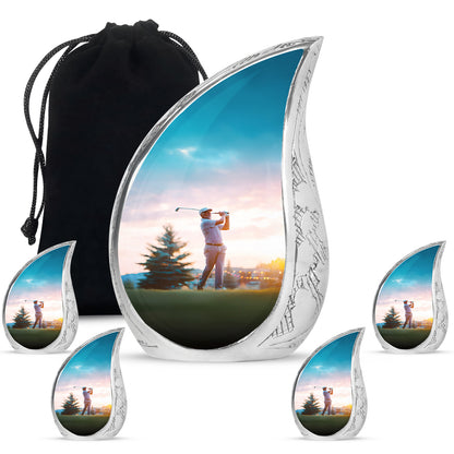 Polished Silver Golf Cremation Urn side profile showing urn shape - smooth teardrop contour featuring golf art - memorial set with one large and four small urns