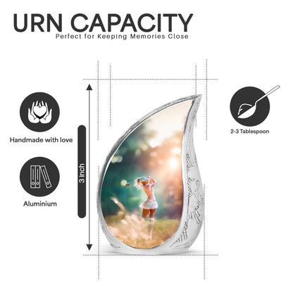Harvest Gold Golf Cremation Urn angled view of lid and engraved motif - smooth teardrop contour featuring golf art - mini keepsake memorial for portion of cremation ashes