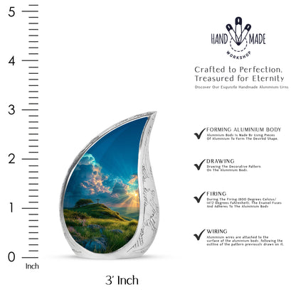 Ocean Teal Cross Cremation Urn angled view of lid and engraved motif - flowing teardrop cross silhouette on curved aluminum - mini keepsake memorial for portion of cremation ashes