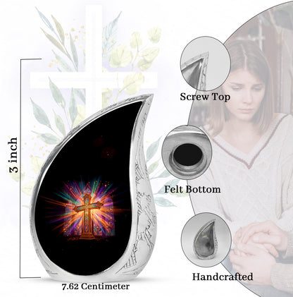 Ebony Cross Cremation Urn angled view of lid and engraved motif - flowing teardrop cross silhouette on curved aluminum - mini keepsake memorial for portion of cremation ashes