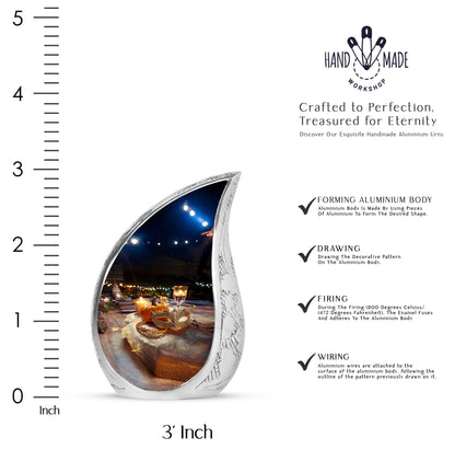 Glossy Black Halloween Cremation Urn angled view of lid and engraved motif - flowing teardrop halloween silhouette on curved aluminum - mini keepsake memorial for portion of cremation ashes