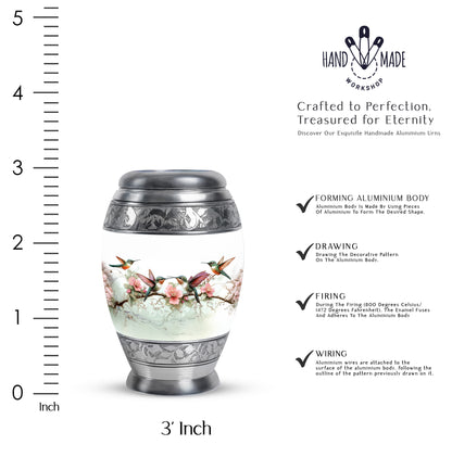 Chrome Silver Hummingbird Cremation Urn lifestyle display on memorial shelf - royal hummingbird engraving with decorative scrollwork - mini keepsake memorial for portion of cremation ashes